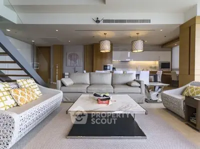 Luxurious open-plan living room with modern decor and stylish furniture, perfect for entertaining.