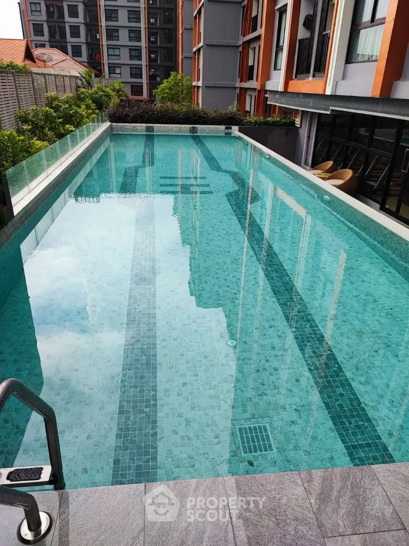 Luxurious apartment complex with a stunning outdoor pool and modern architecture.