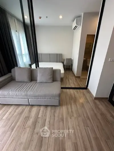 Modern studio apartment with wooden flooring and cozy furniture