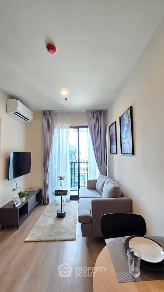 Modern living room with balcony view, stylish decor, and natural light.