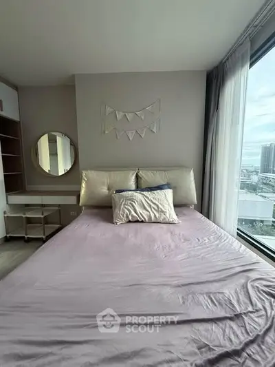 Cozy bedroom with large window offering city view, featuring a comfortable bed and stylish decor.