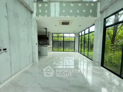 Spacious modern living room with floor-to-ceiling windows and garden view