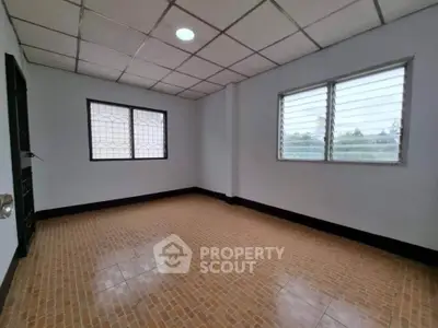 Spacious empty room with tiled floor and large windows, perfect for customization.