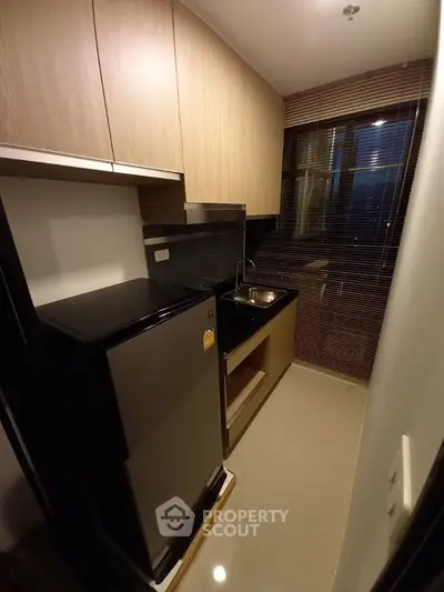 Compact modern kitchen with sleek cabinetry and stainless steel appliances