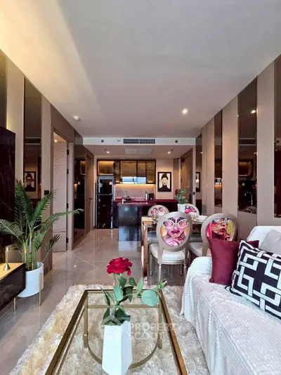 Luxurious open-plan living room with elegant decor and modern kitchen in the background.
