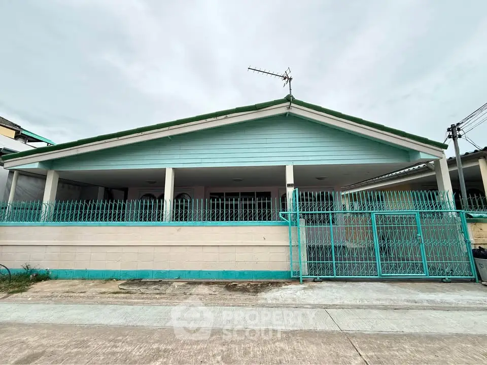 Charming single-story home with a spacious front yard and secure gated entrance, perfect for family living.