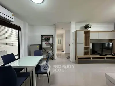 Modern living room with dining area and sleek furniture in a bright, open space.
