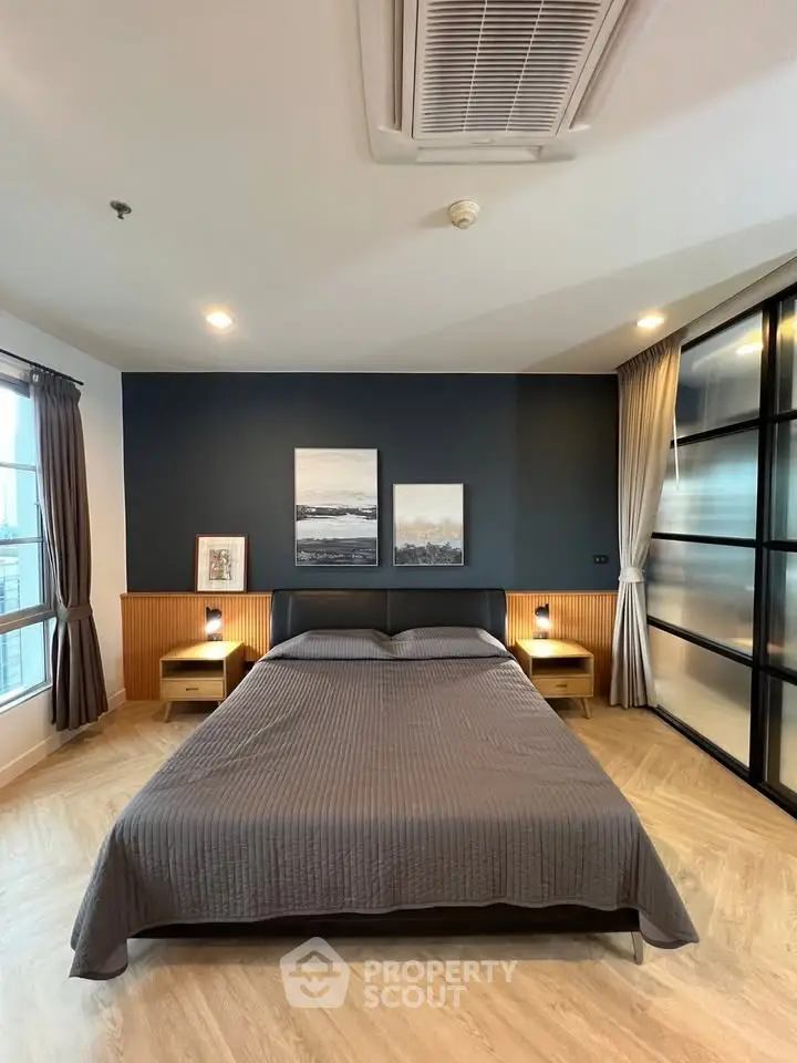 Modern bedroom with stylish decor and large windows in a contemporary apartment.