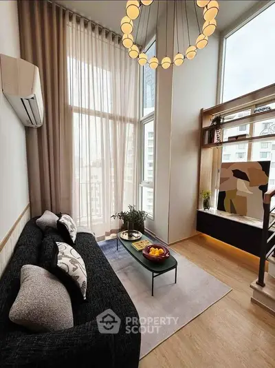 Modern living room with high ceilings, large windows, and stylish decor in a luxury apartment.