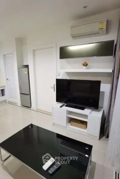 Modern living room with sleek TV setup and air conditioning in a stylish apartment.