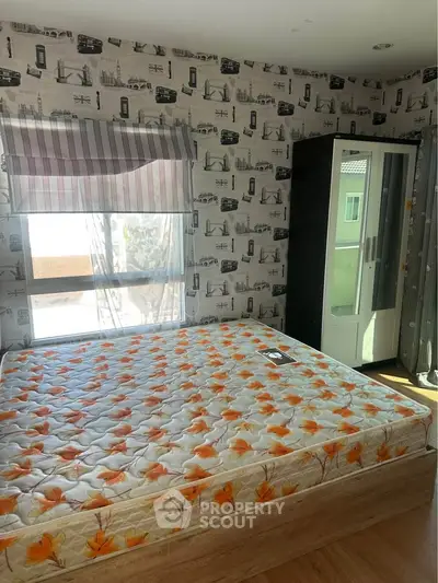 Cozy bedroom with floral mattress and scenic wallpaper, featuring a large window for natural light.