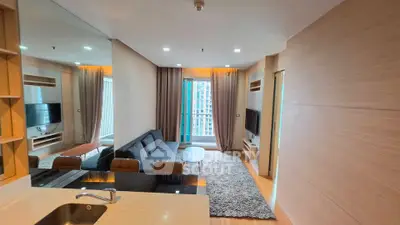 Modern living room with sleek design, large windows, and cozy seating area in a high-rise apartment.