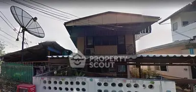 Charming two-story house with unique architectural design and satellite dish, perfect for modern living.