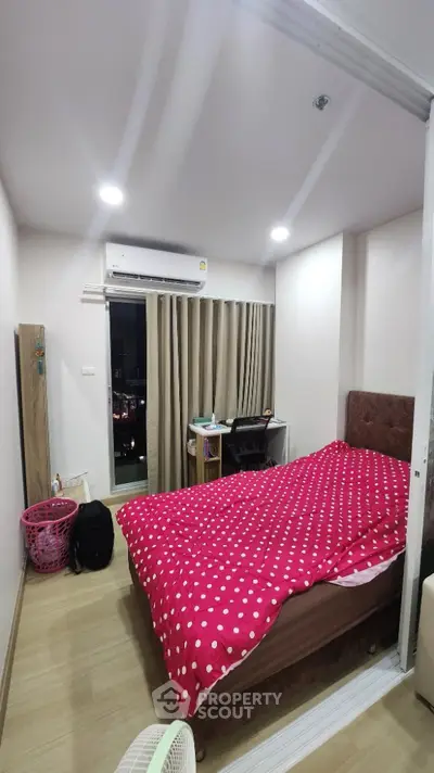 Cozy bedroom with city view, featuring modern decor and ample natural light.