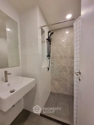 Modern bathroom with sleek shower and stylish sink in contemporary apartment.