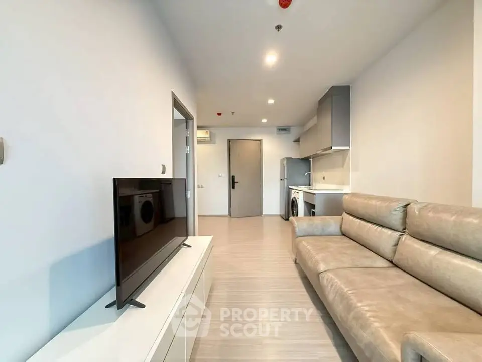 Modern living room with sleek furniture and open kitchen layout in a stylish apartment.