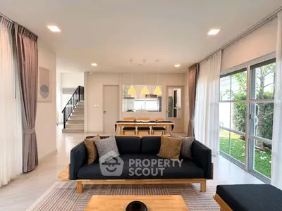 Spacious modern living room with elegant decor and large windows overlooking garden