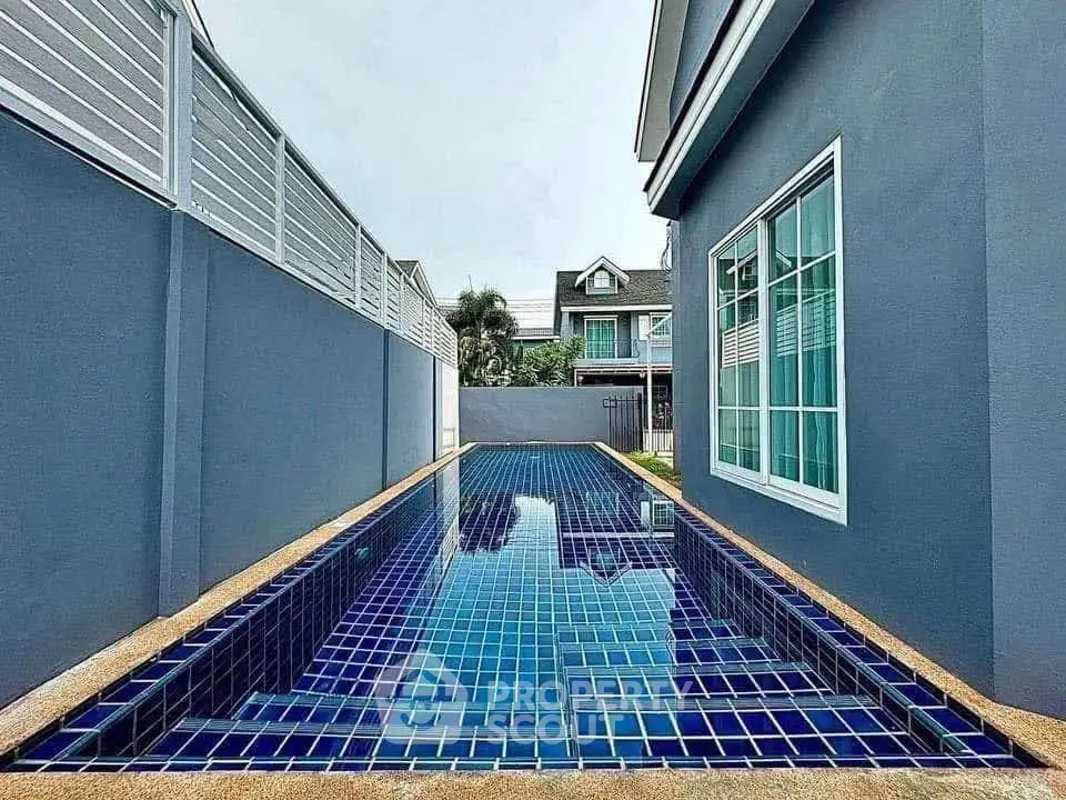 Modern home with sleek blue-tiled private pool and stylish exterior design.