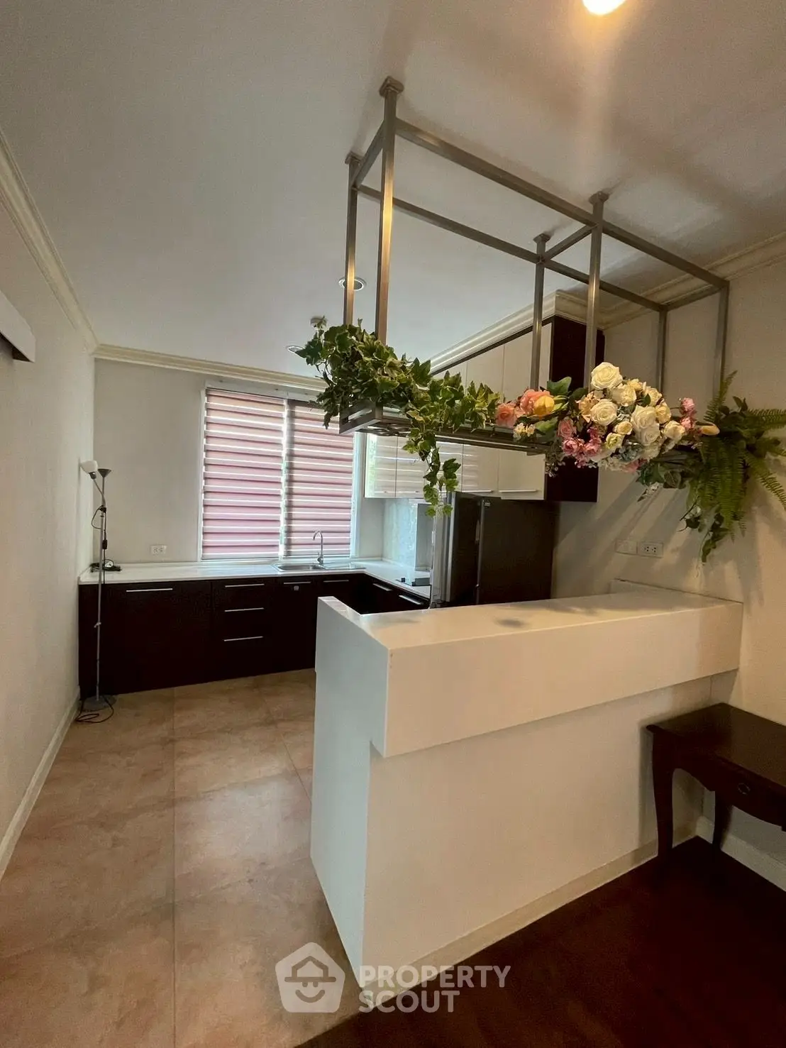 Modern kitchen with sleek black cabinets and elegant floral decor, featuring a stylish open layout and ample natural light.