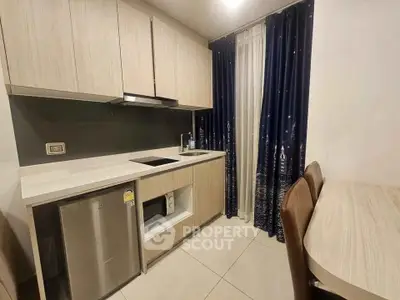 Modern kitchen with sleek cabinetry and dining area in a stylish apartment.
