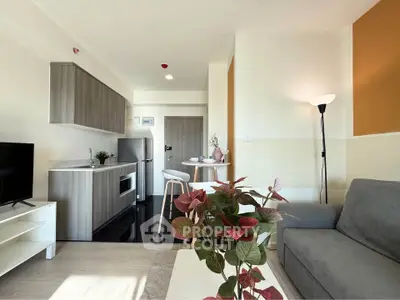 Modern open-plan living room with kitchen, featuring stylish furniture and natural light.