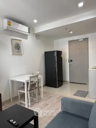 Modern living room with dining area and sleek kitchen appliances in a cozy apartment.