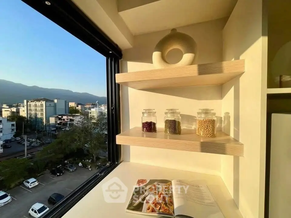 Bright kitchen nook with open shelves and scenic city view, perfect for modern living.