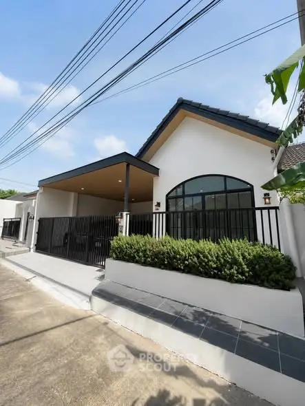 Charming modern house exterior with sleek black fence and lush greenery, perfect for family living.