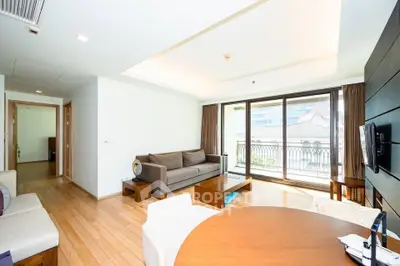 Spacious living room with modern furniture and large windows offering city views.