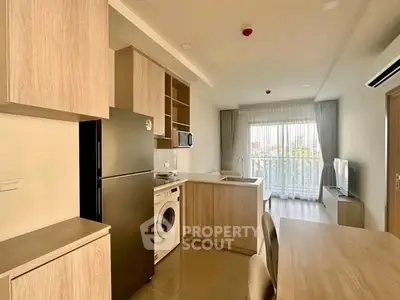 Modern open-layout kitchen with appliances and bright living area in a stylish apartment.