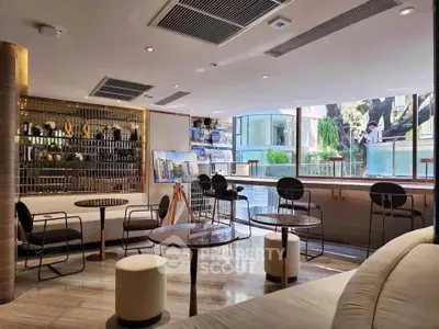 Modern lounge area with stylish seating and large windows offering natural light and city views.
