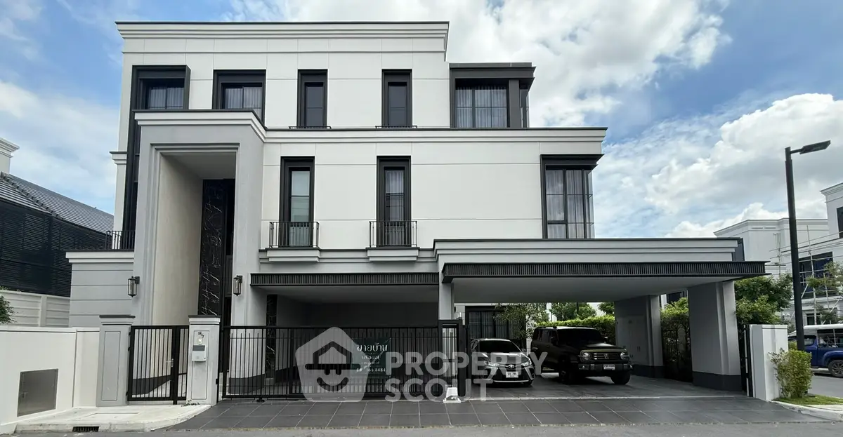 Luxurious modern villa with spacious driveway and elegant facade under a clear blue sky.