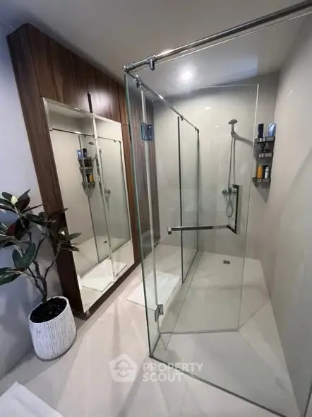 Modern bathroom with glass shower and sleek wooden cabinet