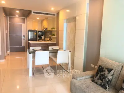 Modern open-layout kitchen and dining area with sleek design and cozy seating.