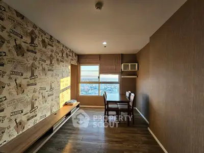 Cozy study room with a travel-themed wallpaper and a scenic city view through the large window, complemented by wooden flooring and built-in shelves.