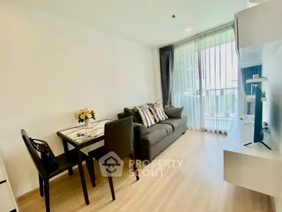 Modern living room with cozy sofa, dining table, and large window for natural light.