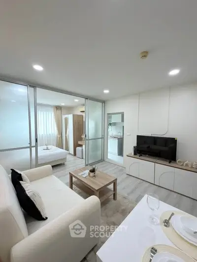 Modern open-plan living room with cozy bedroom and sleek kitchen