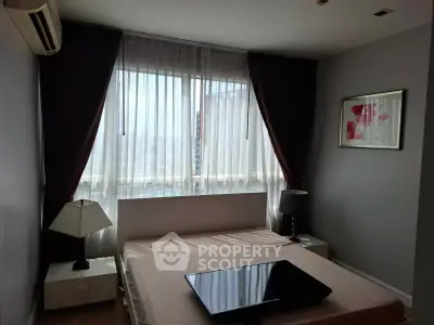 Modern bedroom with large window and elegant decor in a stylish apartment.