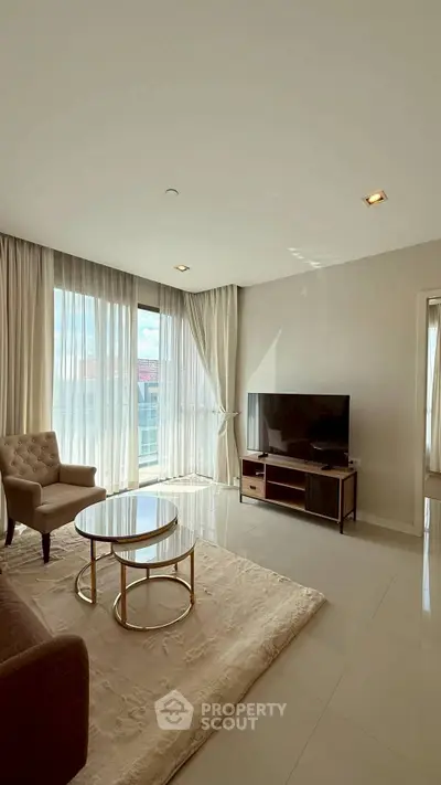 Spacious living room with modern furniture and large windows offering natural light.