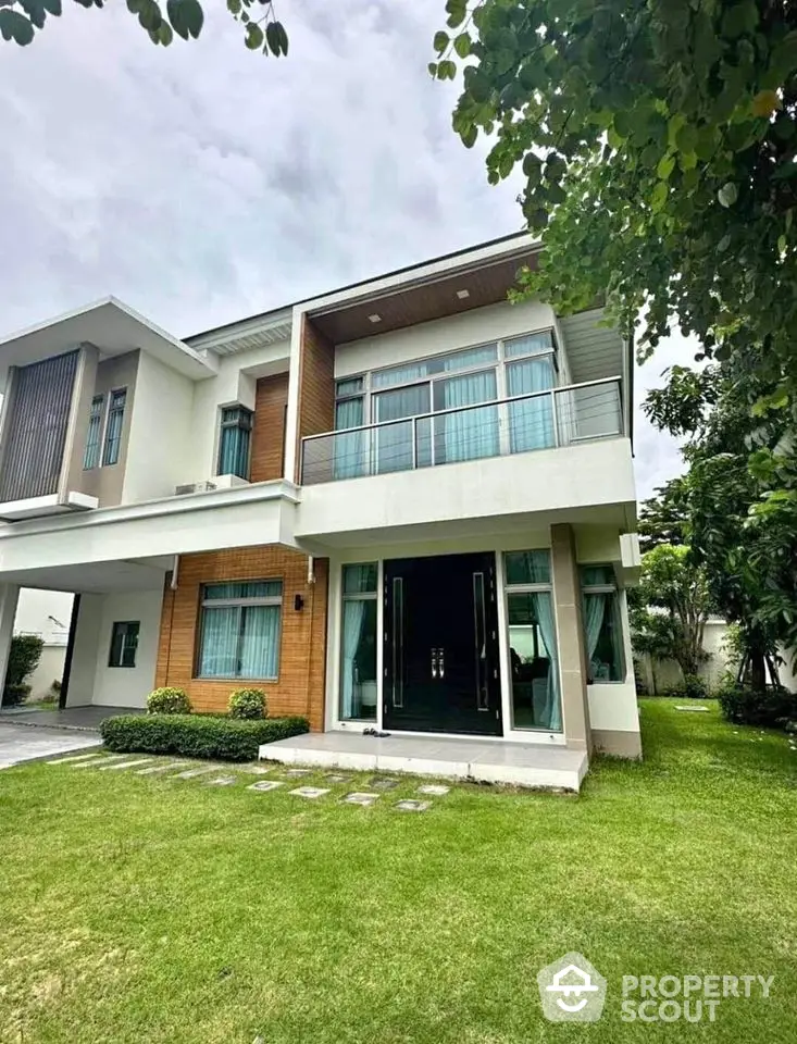 Modern two-story house with lush green lawn and contemporary design