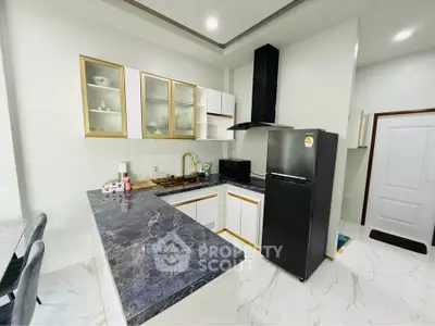 Modern kitchen with sleek black appliances and elegant marble countertops