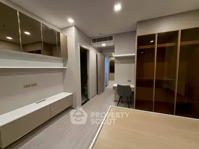 Modern bedroom with sleek design, built-in storage, and elegant lighting in a contemporary apartment.