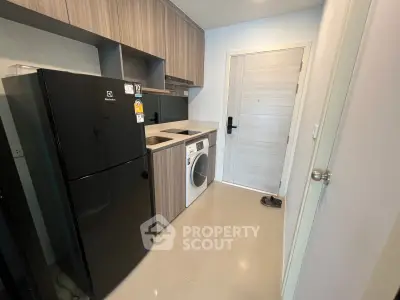 Modern kitchen with sleek appliances and stylish cabinetry in a compact layout.