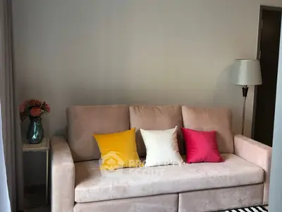 Cozy living room with plush sofa and colorful cushions, perfect for relaxation.
