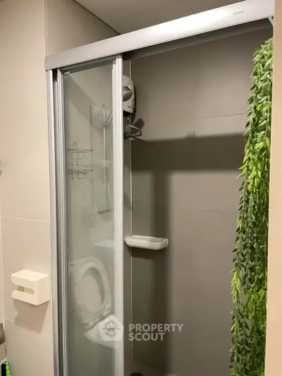 Modern bathroom with glass shower enclosure and sleek tile design.