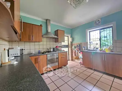 Charming kitchen with wooden cabinets and modern appliances in a cozy home setting.
