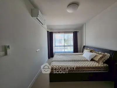 Cozy bedroom with large window and air conditioning, perfect for relaxation.