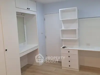 Modern minimalist bedroom with built-in white storage and vanity desk