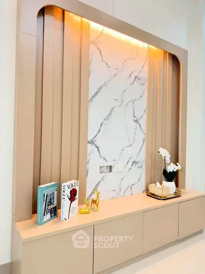 Elegant interior wall feature with marble panel and decorative items, perfect for modern living room design.