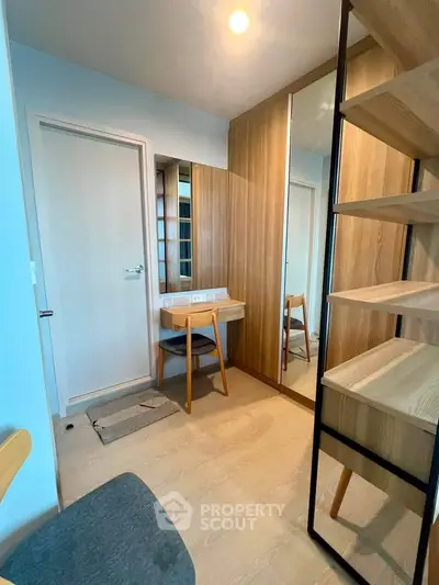 Modern study area with wooden furniture and mirrored closet in a cozy apartment.